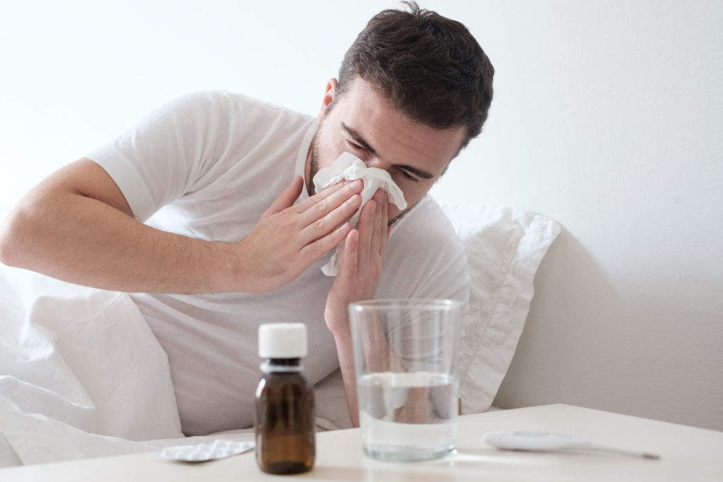 Man Feeling Cold, Lying In The Bed And Blowing His Nose